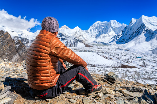 Nepali Sherpa resting and looking at Mount Makalu in Mount Everest National Park.  He is wearing brown jacket. Mount Everest National Park. This is the highest national park in the world, with the entire park located above 3,000 m ( 9,700 ft). This park includes three peaks higher than 8,000 m, including Mt Everest. Therefore, most of the park area is very rugged and steep, with its terrain cut by deep rivers and glaciers. Unlike other parks in the plain areas, this park can be divided into four climate zones because of the rising altitude. http://bem.2be.pl/IS/nepal_380.jpg