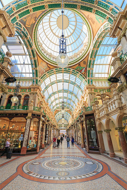Shoppers walking through County Arcade in Leeds, West Yorkshire Leeds, UK - October 02, 2015: Shoppers walking through County Arcade in Leeds, West Yorkshire. This arcade is part of the Victoria Quarter in Leeds. The Victoria Quarter was redeveloped in the late 1980s and is largely populated by upmarket retailers and cafes.   leeds photos stock pictures, royalty-free photos & images