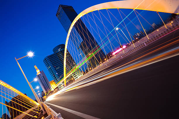 istock Arc bridge girder highway car light trails city night landscape 491732519