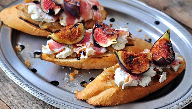 tostar com caramelizado cebola, queijo de cabra, jamon e figos grelhado - onion caramel appetizer bread imagens e fotografias de stock