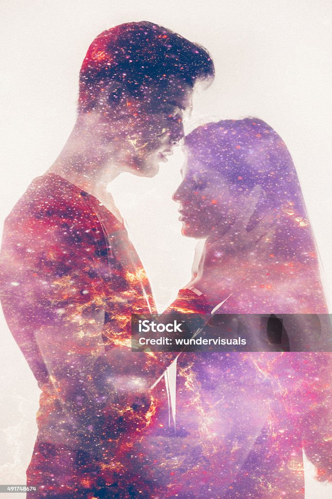 Silhouette of a loving couple with galaxy in their forms Double exposure effect with the forms of a loving couple filled in with a colourful representation of the galaxy in soft pink tones Couple - Relationship Stock Photo