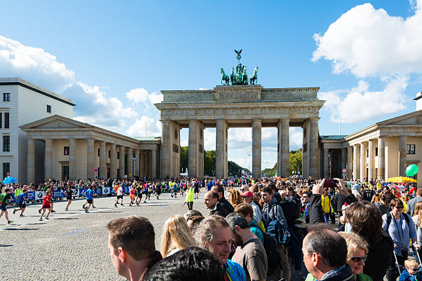 участники берлинский марафон чистовой обработки на бранденбургские ворота - marathon jogging running finishing стоковые фото и изображения