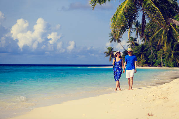 istock happy loving couple walking on summer beach 491752914