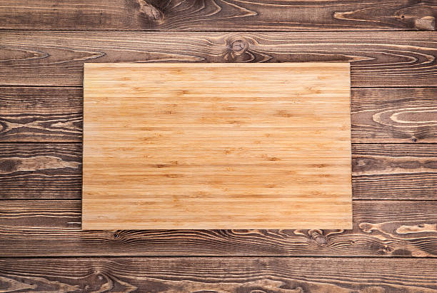 istock cutting board on wooden table. top view 491760964