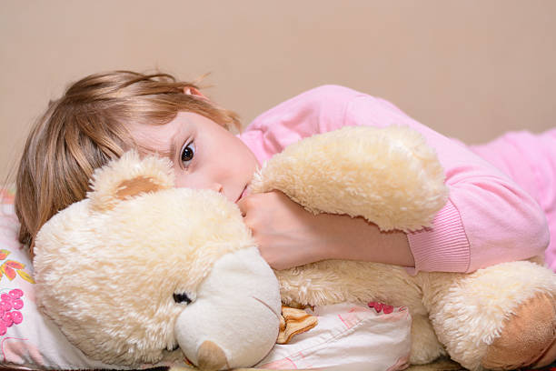 istock Girl lying on the bed with a teddy bear 491765320