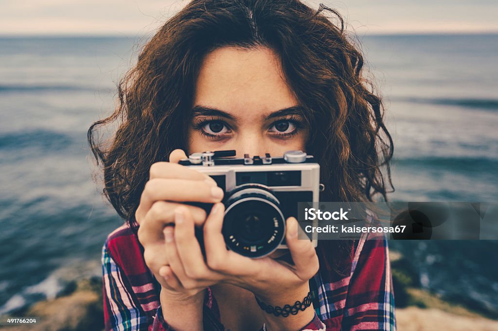 Girl taking a photo at sea with a film camera Retro Style Stock Photo