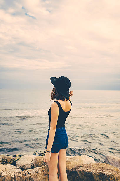 istock Girl with hat standing on a pier 491773286
