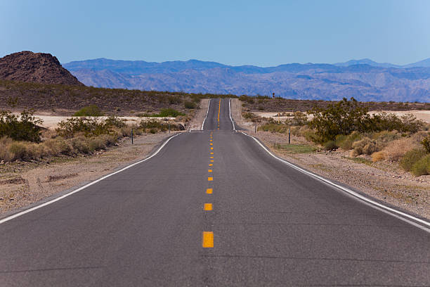 istock Straight road with lines in desert, California 491773682