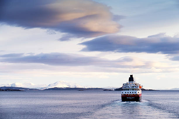 Harstad,Norway - March 2, 2015:The  Hurtigruten cruise ship MS Richard With is sailing the waters just outside the town of Harstad. The ship is sailing northbound towards its next destination on its journey from Bergen to Kirkenes. Some people are standing on the decks of the ship. 