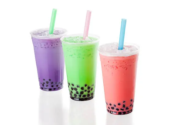 Three colourful glasses of bubble tea on white background.