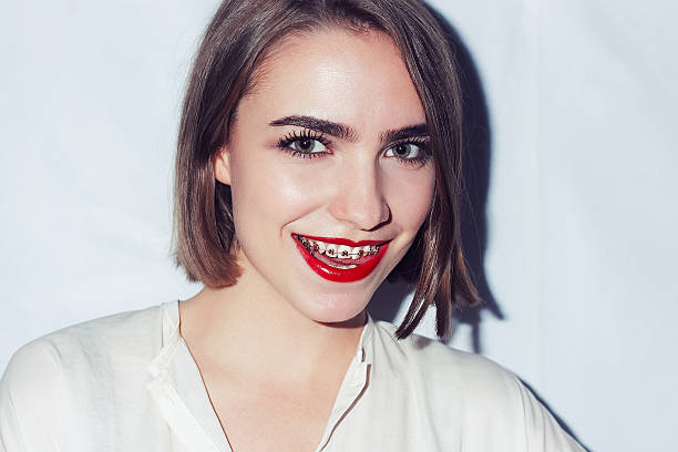 retrato de mujer joven con aparatos de ortodoncia dentista natural - tournament bracket fotos fotografías e imágenes de stock