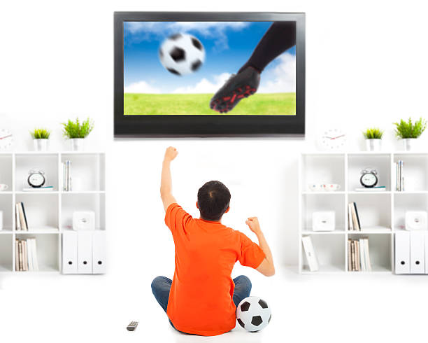 istock happy fan watching soccer game and raised hands 491782231