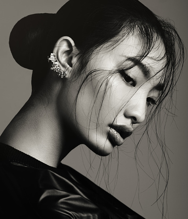 Portrait of asian beautiful woman with statement ear cuff. Professional make-up and hairstyle. High-end retouch.