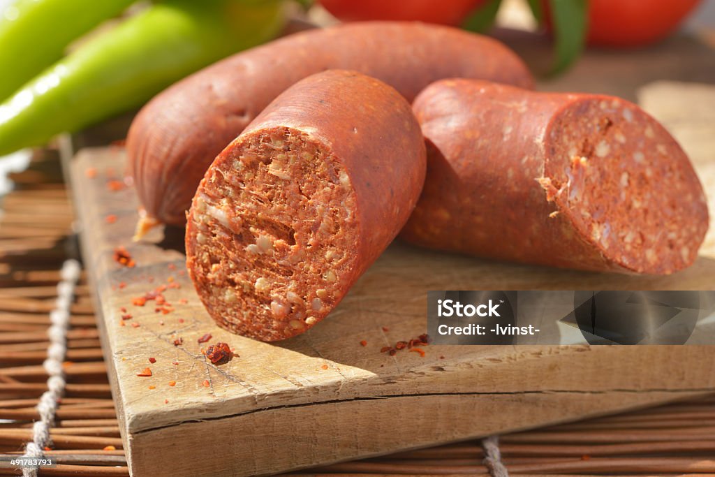 Sucuk on a cutting board Turkish sausage sucuk on a cutting board Aleppo Pepper Stock Photo