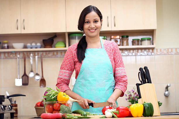 légumes coupe jeune femme indienne - stereotypical homemaker photos et images de collection