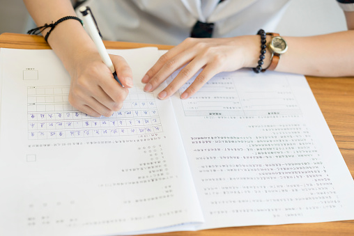 Female student writing Chinese exame, Hong Kong, China, Asia.