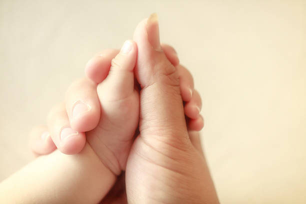 istock baby holding his mothers finger, selective focus 491785577