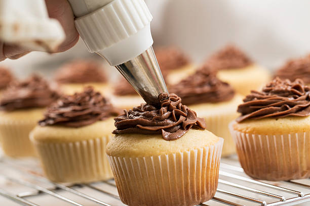 fotografii de stoc, fotografii și imagini scutite de redevențe cu cupcakes glazură - chocolate icing