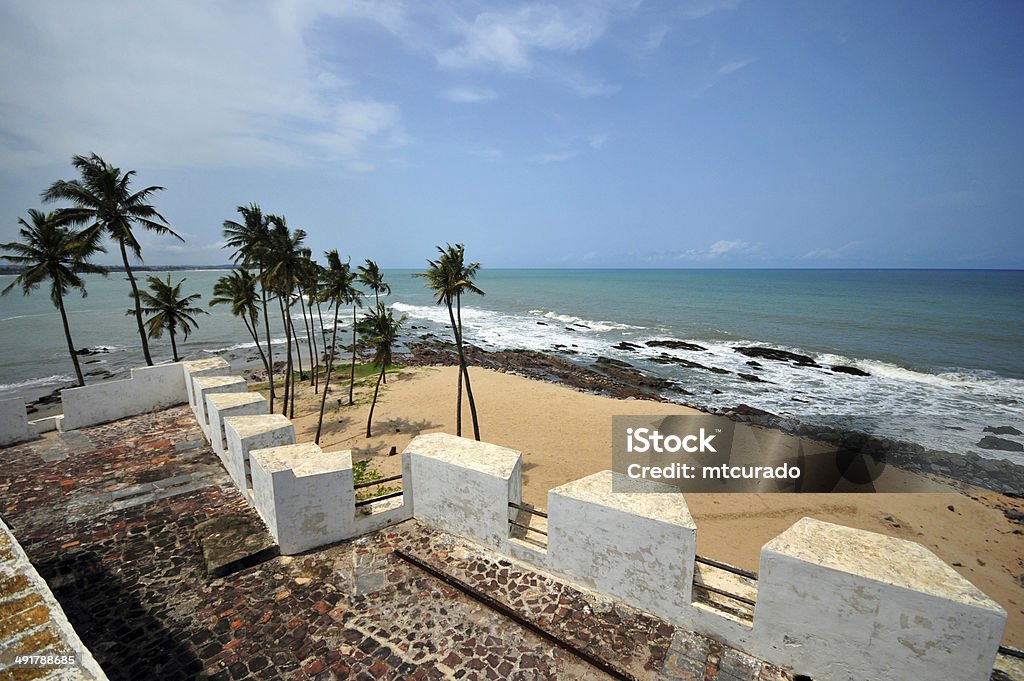 Ghana, West Africa: Elmina castle Elmina, Ghana: Elmina Castle parapet with crenellation - coconut trees and the beach - São Jorge da Mina castle, Feitoria da Mina, Gold Coast - Unesco world heritage site - photo by M.Torres Africa Stock Photo