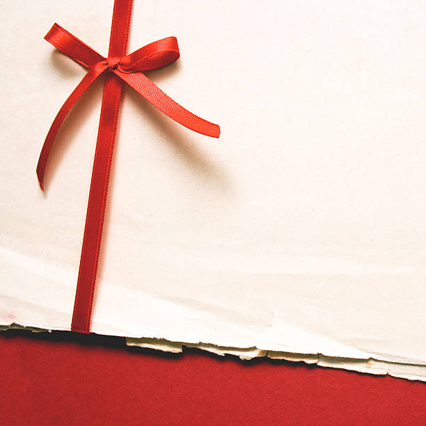 istock Red gift bow with ribbons and blank old paper on red paper 491789111