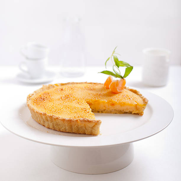 tangerina bolo de creme queimado em um fundo branco - creme brulee tart custard dessert imagens e fotografias de stock