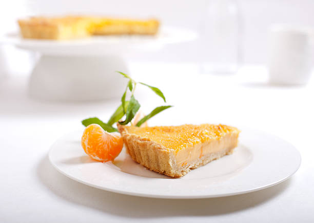 tangerina bolo de creme queimado em um fundo branco - creme brulee tart custard dessert imagens e fotografias de stock