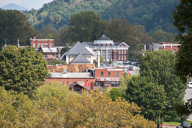 A photo of a typical small mountain town in the United States of America. Features old brick buildings, that house stores, restaurants and an historical Methodist Church. Photo is of the town of Murphy North Carolina. Photo shows Tennessee street and the First Methodist Church .