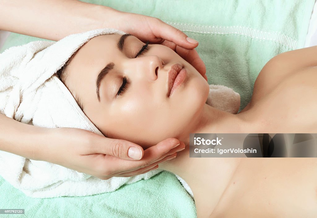 anti aging facial massage beautiful and young girl doing anti-aging facial massage 2015 Stock Photo