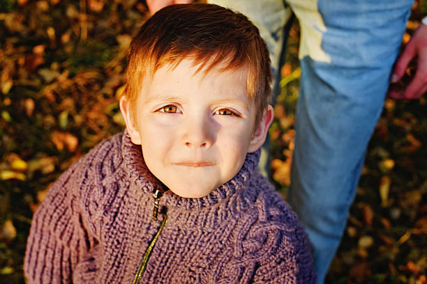 istock boy looks at camera in autumn Park 491793394