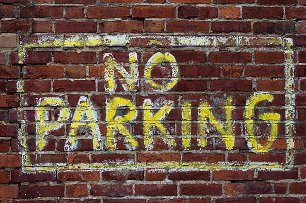istock No parking sign painted on brick wall 491800866