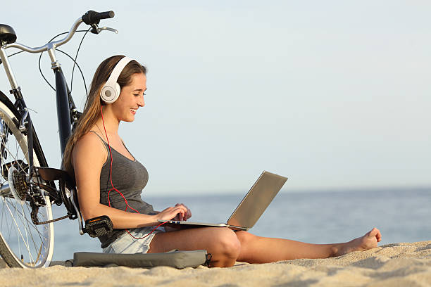 adolescente chica estudiando con una computadora portátil en la playa - video conference camera fotografías e imágenes de stock