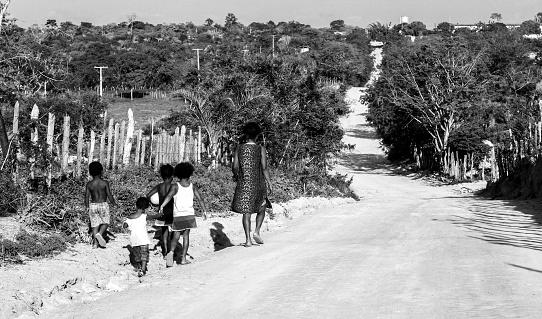 Piritiba, Ba, Brazil - December 29, 2013: Mother and her children, walking on a dirt road toward the city.