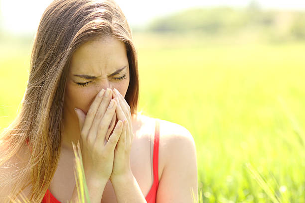 istock Woman with allergy coughing in a field 491804164