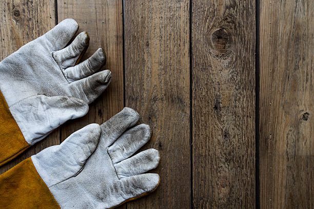 istock old dirty leather work gloves on wood background 491804608