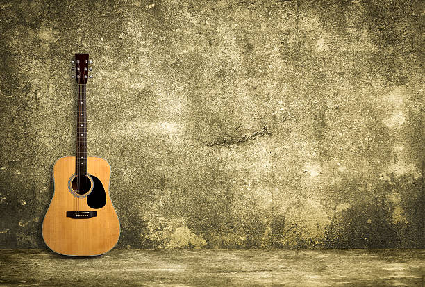 istock Acoustic guitar against old wall 491805412