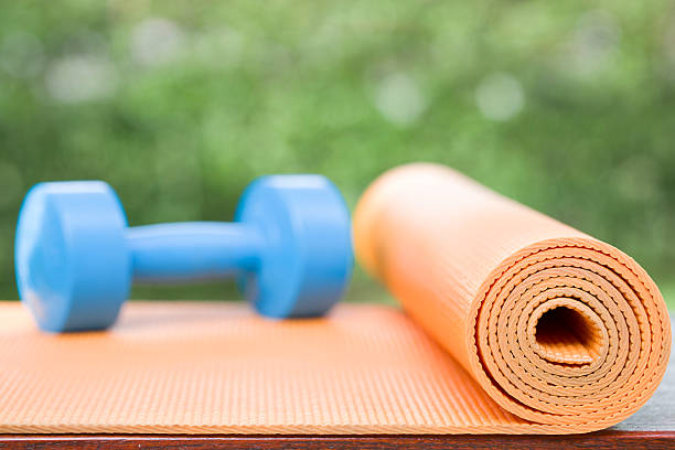istock orange yoga mat and blue dumbbell 491805546