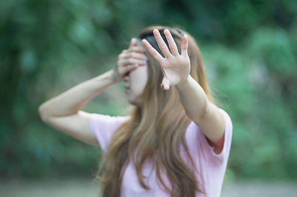 istock asia woman covers her face with hand shows stop 491806716