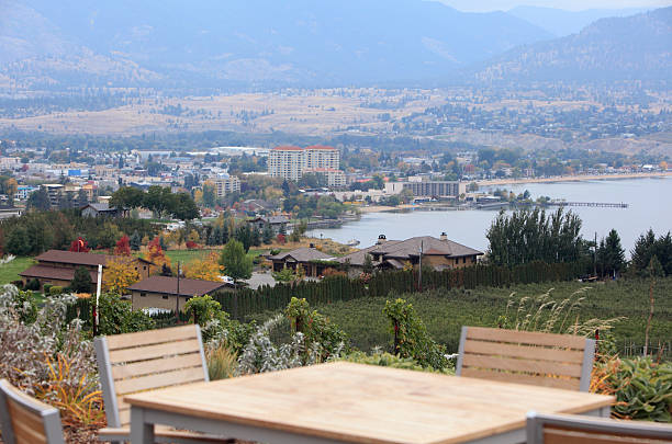 View of Penticton BC from above.  Fall season.  Table and chairs in foreground. Lake Okanagan. Vineyard below.