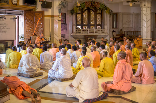 New Delhi, India - September 10, 2015 : Devotees sitting and listening to sermons by a monk at ISKCON Temple, New Delhi, India. Sermons and Preachings are conducted here everyday at ISKCON for the resident monks and visiting devotees.