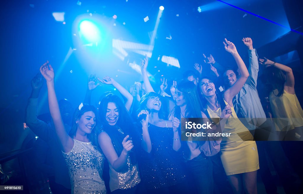 Friends at a karaoke party Group of friends having fun at a karaoke party singing and dancing at a nightclub Party - Social Event Stock Photo