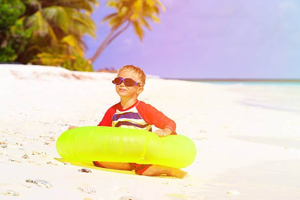 istock little boy playing with life ring at tropical beach 491827470