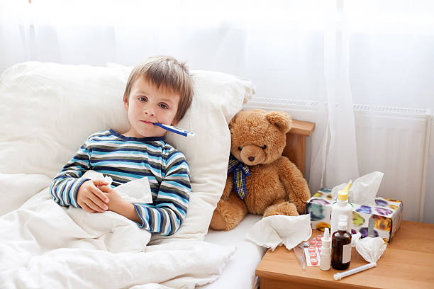 malattia bambino ragazzo di mentire a letto con la febbre, riposo - child fever illness thermometer foto e immagini stock