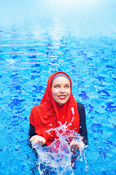 muslim caucasian woman swimming in a swimming pool - 回教泳裝 圖片 個照片及圖片檔