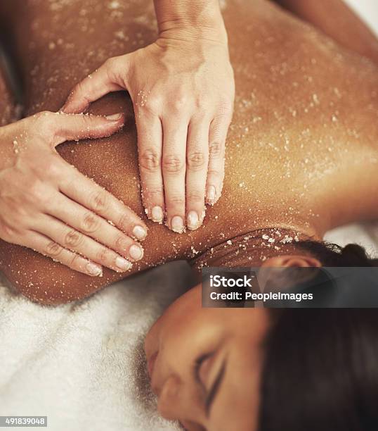 Indulging A Luxurious Back Scrub Stock Photo - Download Image Now - Exfoliation, The Human Body, Massaging