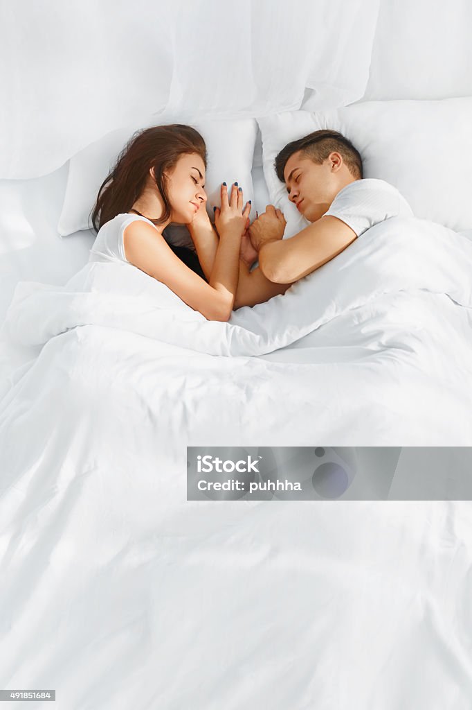 Portrait of couple sleeping in the bed Portrait of young lovely couple sleeping in the bed on white blankets faced to each other. Healthy lifestyle. Relationships , closeness. Sleeping Stock Photo