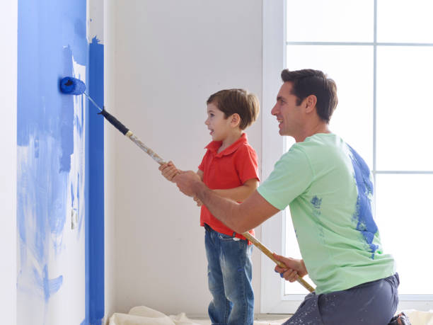 istock Father and son painting wall together 491858230