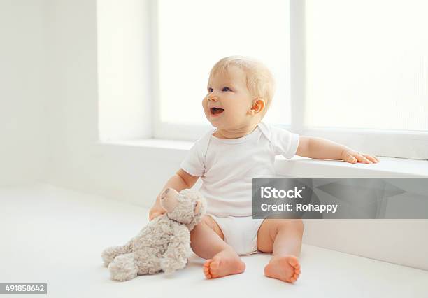 Cute Smiling Baby With Teddy Bear Toy Home In Room Stock Photo - Download Image Now - Baby - Human Age, Sitting, 12-17 Months