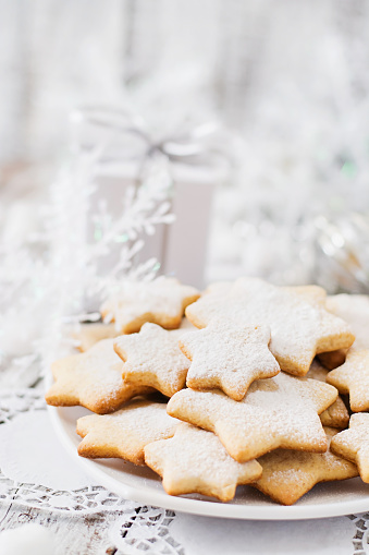 Christmas cookies and tinsel on a light wooden background