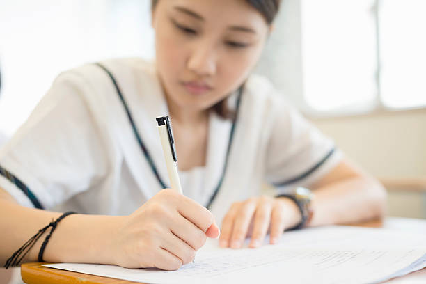 Young Chinese Woman Writing Final Exam, Hong Kong, China, Asia stock photo