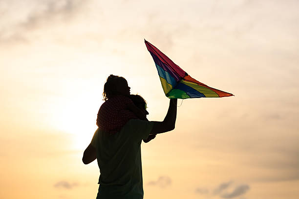istock father and little daughter flying kite at sunset 491871238